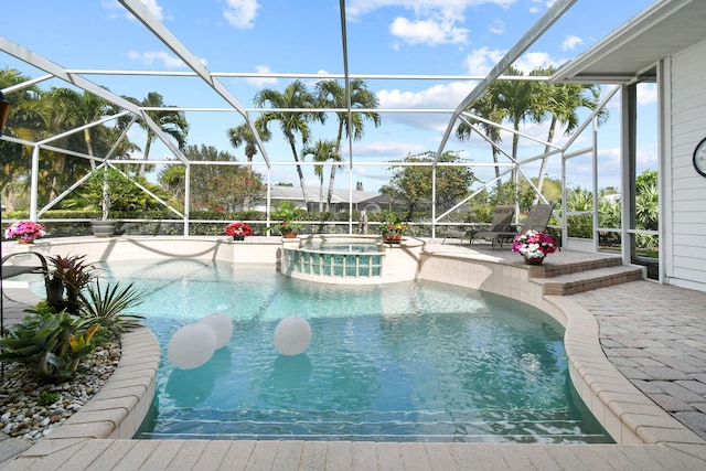 view of pool with a patio area, a pool with connected hot tub, and glass enclosure