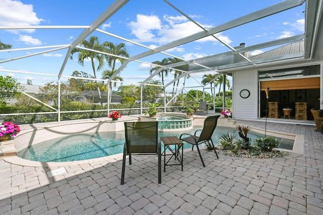 view of pool featuring a pool with connected hot tub, a patio, and a lanai