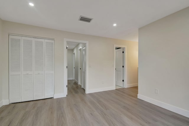 unfurnished bedroom featuring light hardwood / wood-style flooring and a closet