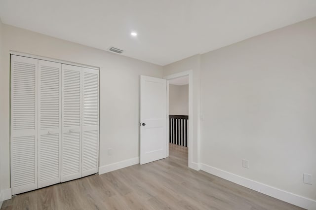 unfurnished bedroom with light hardwood / wood-style floors and a closet