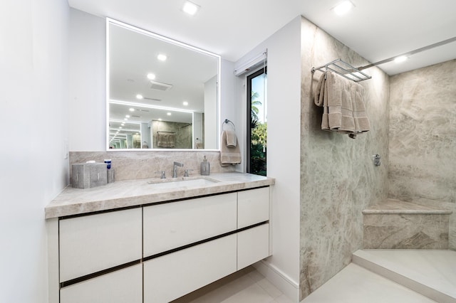 bathroom with vanity, decorative backsplash, and a shower