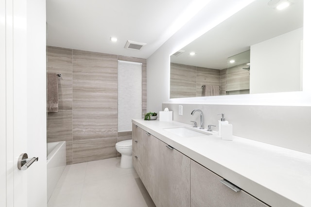 bathroom with tile patterned flooring, vanity, tile walls, and toilet