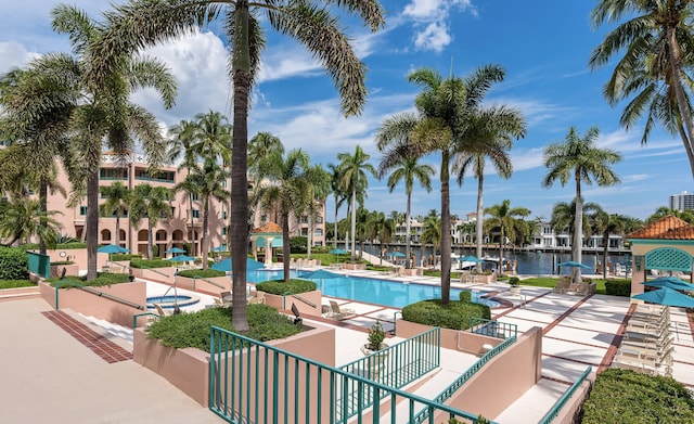 view of pool with a patio and a water view