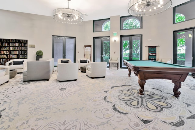 game room with carpet, a healthy amount of sunlight, an inviting chandelier, and french doors