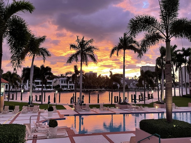 view of community with a pool, a patio area, and a water view