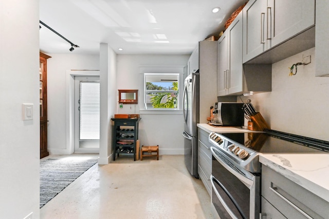 kitchen featuring stainless steel appliances, light stone countertops, and gray cabinetry