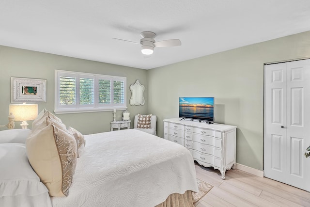 bedroom featuring ceiling fan, light wood finished floors, a closet, and baseboards