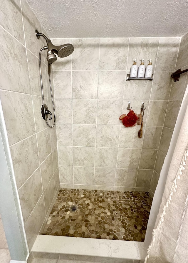 bathroom with a textured ceiling and walk in shower