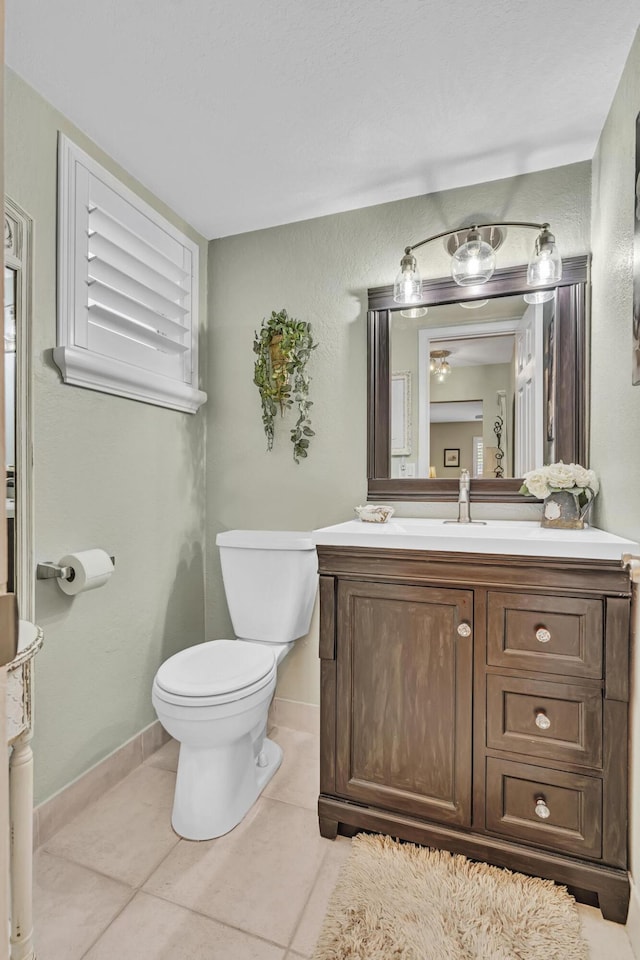 bathroom with tile patterned flooring, vanity, and toilet