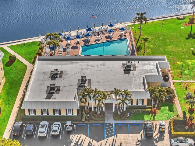 view of swimming pool with a grill, a patio, and a water view