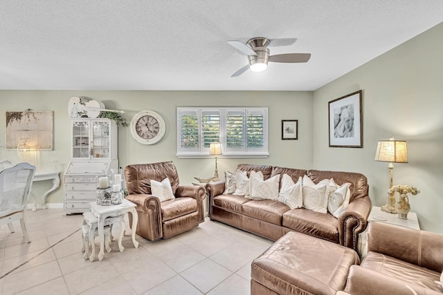 living room featuring a ceiling fan, a textured ceiling, and light tile patterned floors