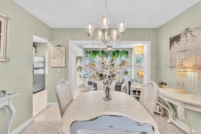 tiled dining space featuring a notable chandelier