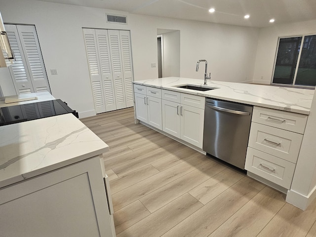 kitchen with sink, light hardwood / wood-style flooring, dishwasher, white cabinetry, and light stone countertops