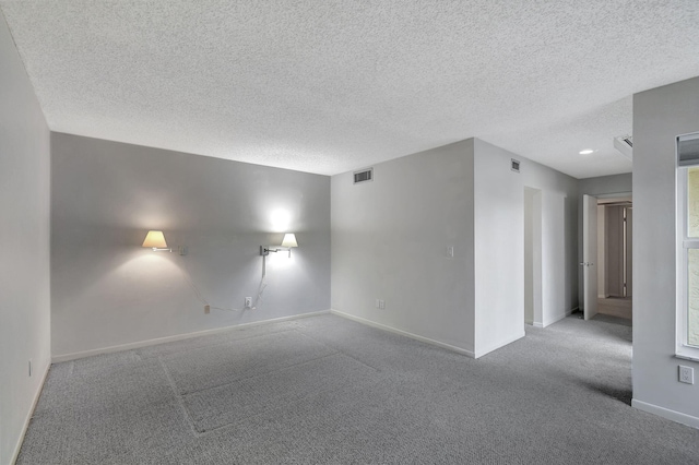 unfurnished room with light carpet and a textured ceiling