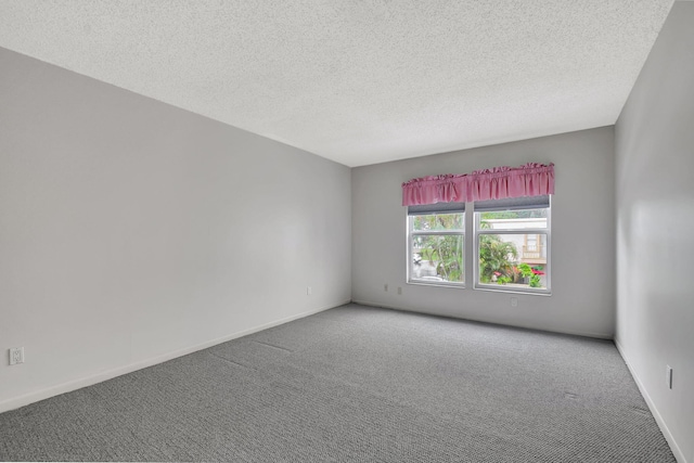 empty room with carpet and a textured ceiling