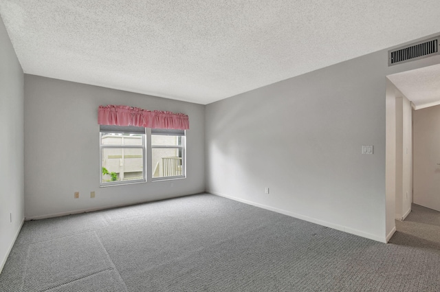 carpeted spare room with a textured ceiling