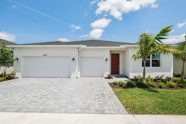 ranch-style house featuring a garage, stucco siding, decorative driveway, and a front yard