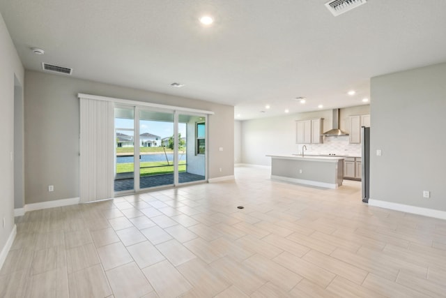 unfurnished living room featuring baseboards, visible vents, and recessed lighting