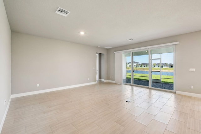 empty room with recessed lighting, visible vents, and baseboards