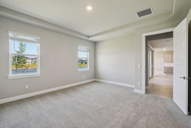 empty room featuring carpet, visible vents, recessed lighting, and baseboards