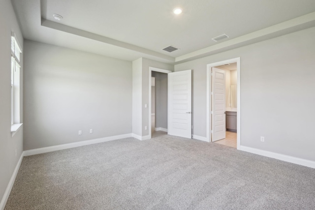 unfurnished bedroom featuring visible vents, light colored carpet, and baseboards