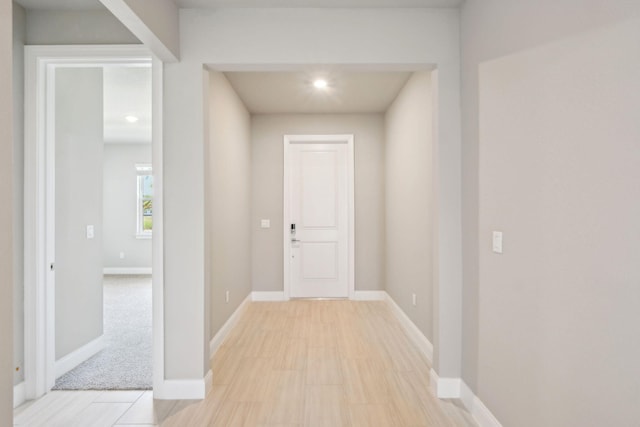 hall with baseboards and recessed lighting