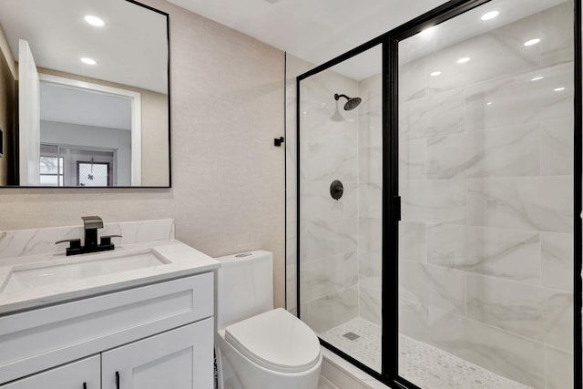 bathroom with walk in shower, vanity, and toilet