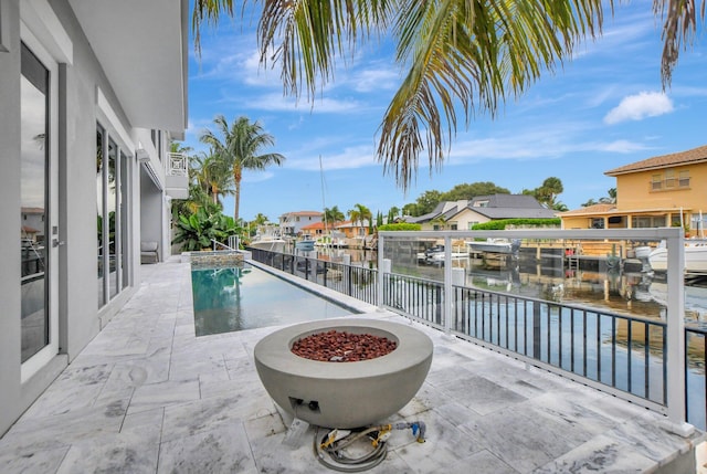 exterior space with a patio area, an outdoor fire pit, and a water view