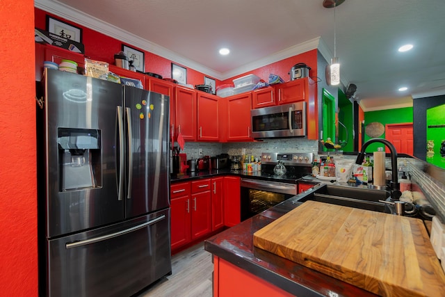 kitchen featuring decorative backsplash, light wood-style flooring, appliances with stainless steel finishes, crown molding, and a sink