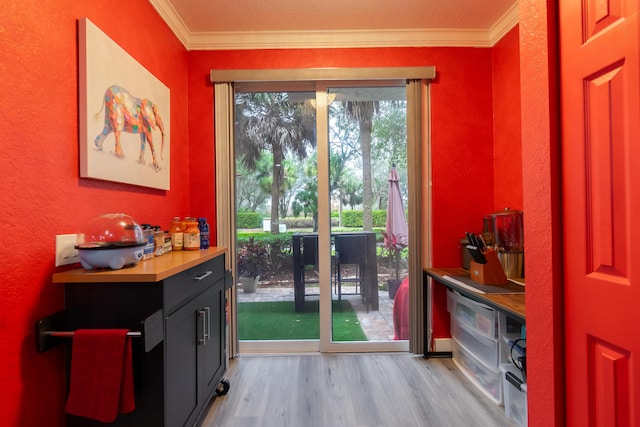 entryway featuring ornamental molding and light wood-type flooring