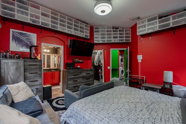 bedroom featuring stacked washer / dryer and visible vents