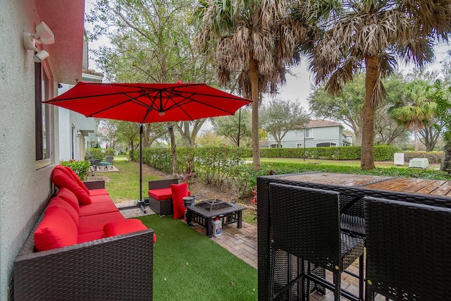 view of patio with an outdoor living space with a fire pit