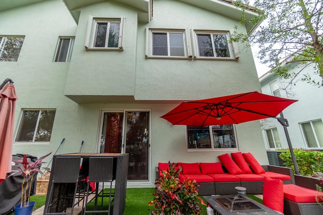 rear view of house with an outdoor hangout area and stucco siding