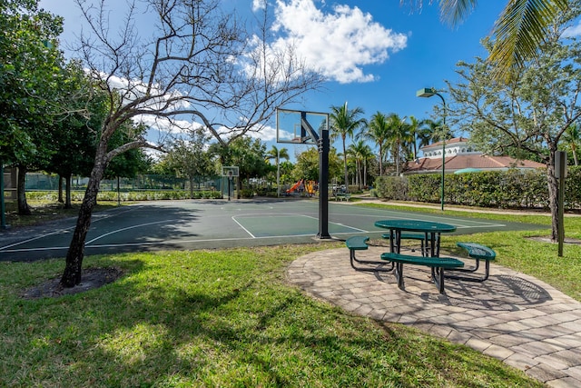 view of sport court with a yard, community basketball court, and fence