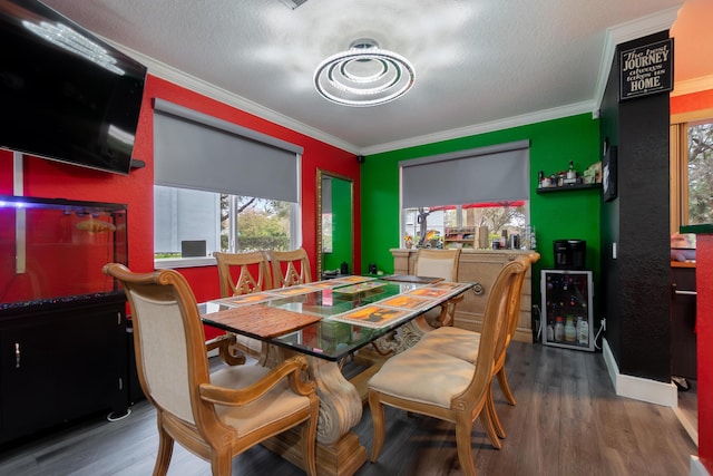 dining space featuring ornamental molding, wine cooler, and wood finished floors