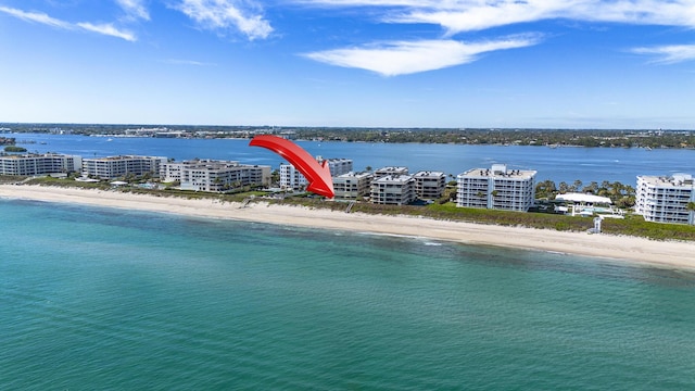 birds eye view of property featuring a water view and a beach view