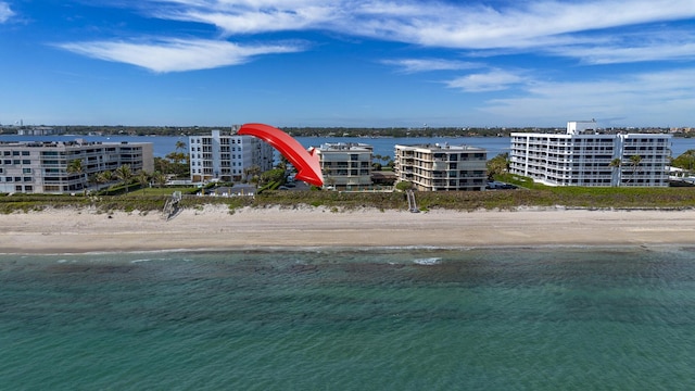 birds eye view of property featuring a water view and a beach view