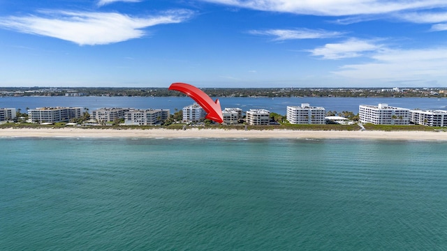 birds eye view of property with a water view and a beach view