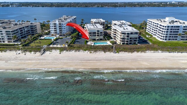 birds eye view of property with a beach view and a water view