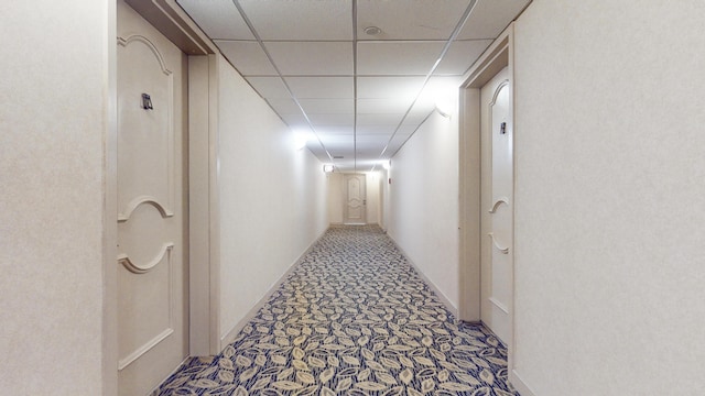 hallway with a paneled ceiling