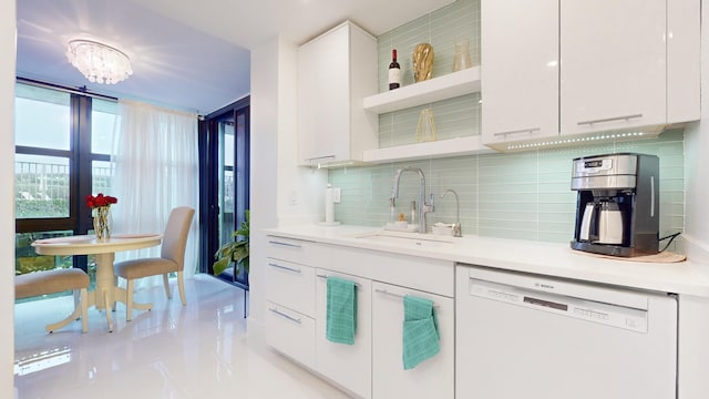 kitchen with sink, white cabinetry, light tile patterned floors, white dishwasher, and decorative backsplash