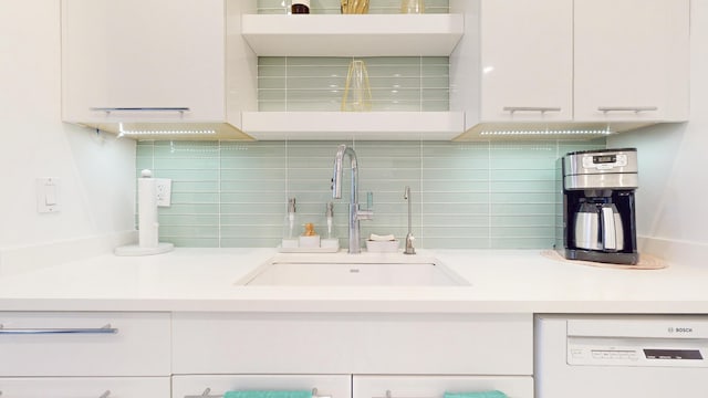 kitchen featuring white dishwasher, sink, white cabinetry, and tasteful backsplash