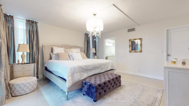 bedroom with multiple windows, connected bathroom, and a chandelier