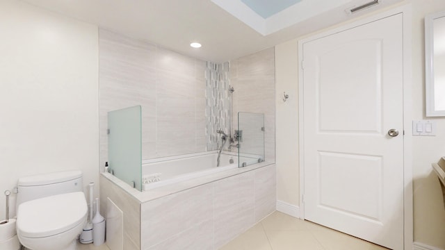 bathroom featuring tiled shower / bath, toilet, and tile patterned flooring