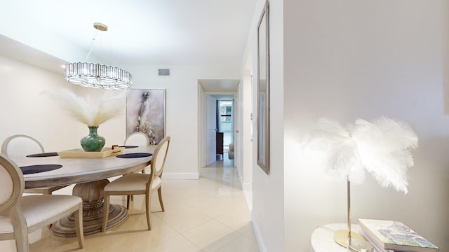 tiled dining space with an inviting chandelier