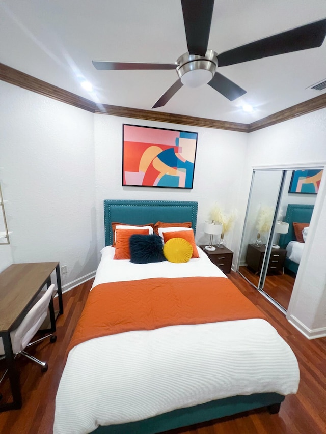 bedroom with dark wood-type flooring, ornamental molding, a closet, and ceiling fan