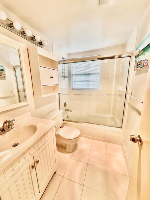 full bathroom featuring toilet, tile patterned floors, shower / bath combination with glass door, and vanity