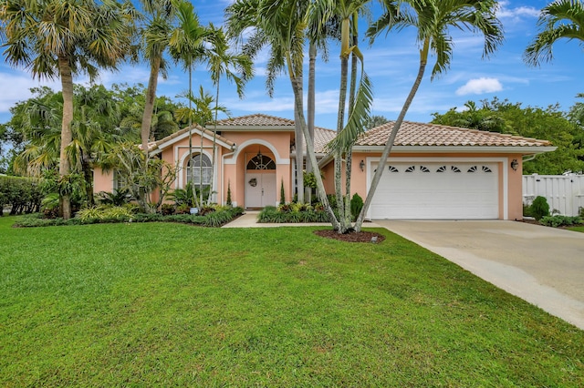 mediterranean / spanish-style home with a garage and a front lawn