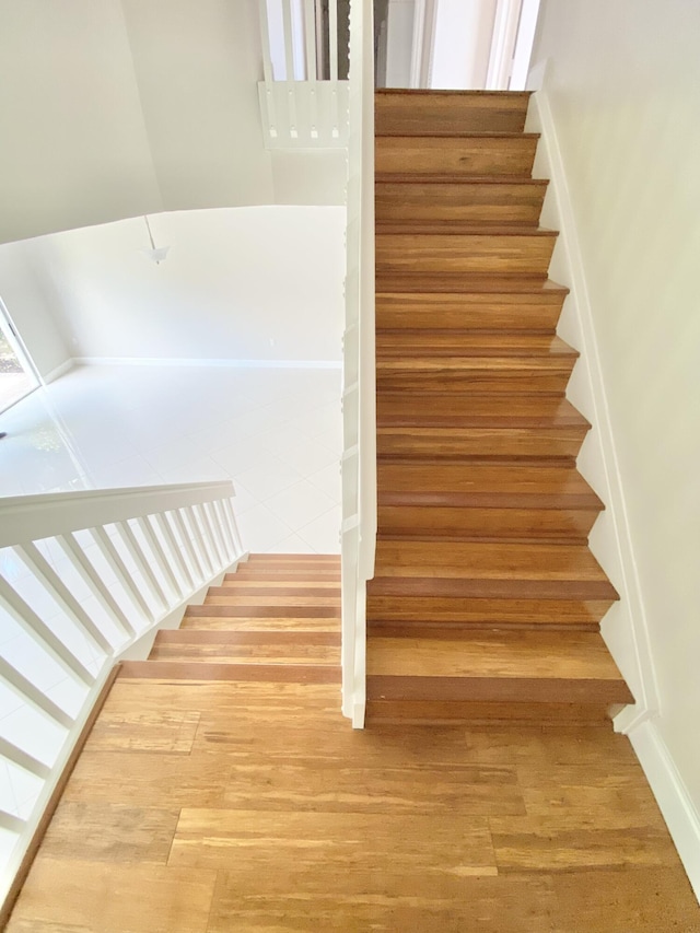 stairway with hardwood / wood-style floors