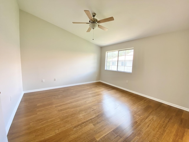 empty room featuring lofted ceiling, hardwood / wood-style floors, and ceiling fan